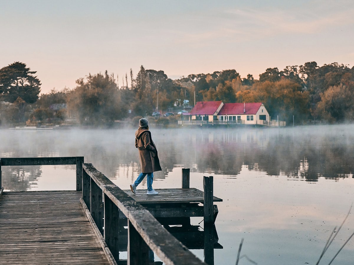 a woman standing on the edge of Lake Daylesford Bridge