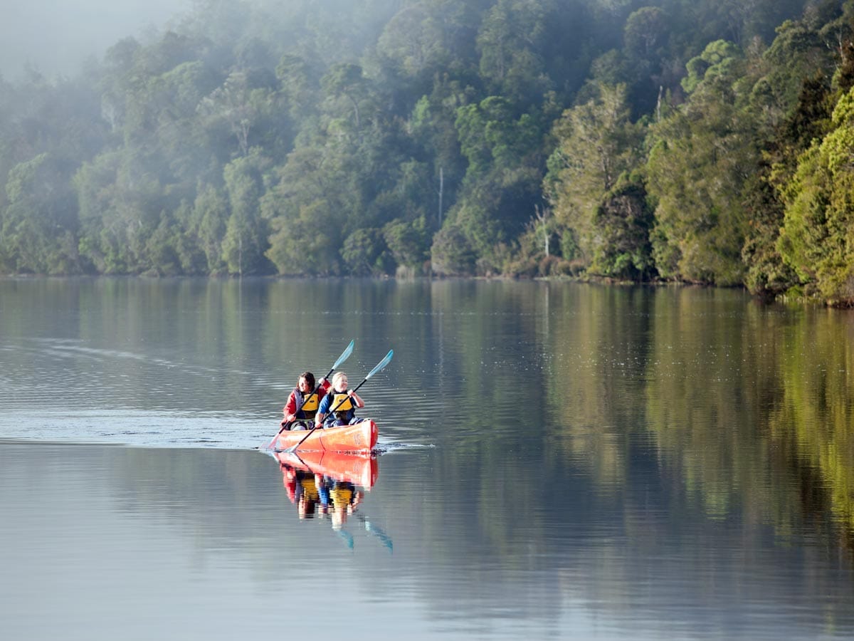 a mother and daughter kayaking through the waters of Pieman River