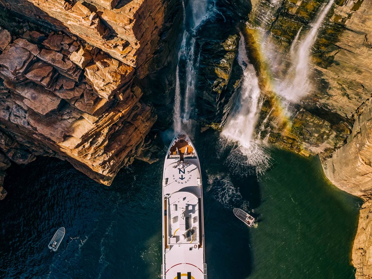 People gather on the deck under King George Falls in the Kimberley on a True North cruiise