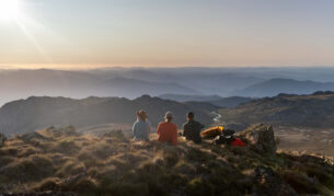 Three people oat the summit of Ramshead Hike in Kosciuszko National Park